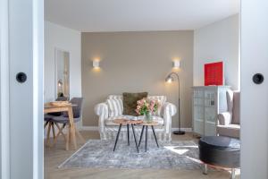 a living room with a table with flowers on it at Louis in Westerland (Sylt)