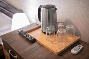 a coffee pot and glasses on a wooden table at Lotus Hotel in Tbilisi City