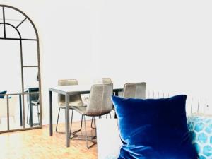 a dining room with a table and chairs and a blue pillow at Home far from home in central London in London