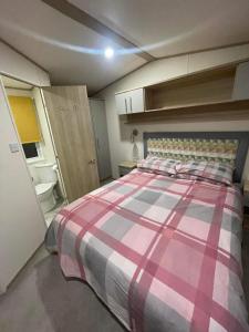 a small bedroom with a bed and a bathroom at Cosy Holiday Home, Home Farm Holiday Park in Brent Knoll