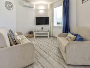 Sala de estar con 2 sofás y TV en Villa Chicca by Interhome, en Badesi