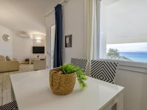una sala de estar con una mesa blanca con una planta. en Villa Chicca by Interhome, en Badesi