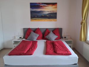 um quarto com uma cama com almofadas vermelhas em Holiday Home Marion by Interhome em Saalfelden am Steinernen Meer