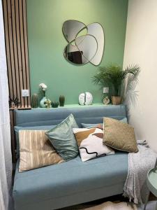 Sofá azul con almohadas y espejo en Une mise au vert en centre ville, en Sens