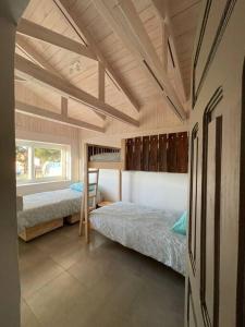 a bedroom with two bunk beds and a window at Casa La Escondida, Punta Sirena in Pelluhue