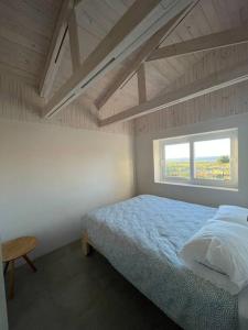 a bedroom with a bed and a window at Casa La Escondida, Punta Sirena in Pelluhue