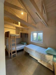 a room with two bunk beds and a window at Casa La Escondida, Punta Sirena in Pelluhue
