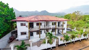 uma casa branca com um telhado vermelho em MICASO Guest House em Limbe