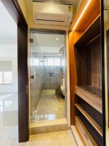 a bathroom with a glass door leading to a toilet at Ultra stylish 3bhk & home theatre room in Hyderabad