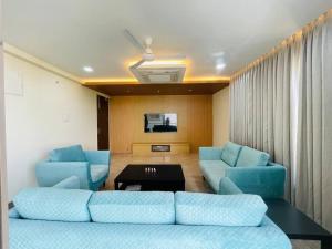 a living room with blue couches and a table at Ultra stylish 3bhk & home theatre room in Hyderabad