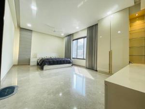 a bedroom with a bed in the middle of a room at Ultra stylish 3bhk & home theatre room in Hyderabad