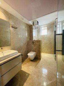 La salle de bains est pourvue de toilettes, d'un lavabo et d'une douche. dans l'établissement Ultra stylish 3bhk & home theatre room, à Hyderabad