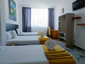 a hotel room with two beds and a couch at Patty House Galapagos in Puerto Ayora