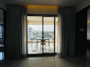a room with sliding glass doors with a table and a view at Ultra stylish 3bhk & home theatre room in Hyderabad