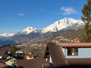 a view of snow capped mountains from a city at Apartment Tilleul by Interhome in Grimisuat