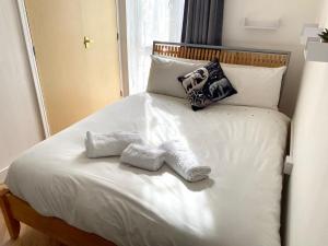 ein Bett mit zwei Handtüchern darüber in der Unterkunft Norwich Apartment - Cosy & Comfortable 1 Bedroom in Goodmayes
