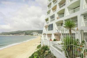 - une vue sur un hôtel et la plage dans l'établissement Apartamento Sol da Falésia, à Sesimbra