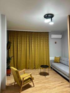 een woonkamer met een bank en een stoel bij Double Studio near University Square - 2 Balconies in Boekarest +17 foto's
