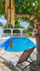 una hamaca y una silla junto a la piscina en Villa Elisa, un paradis à Figari, en Figari