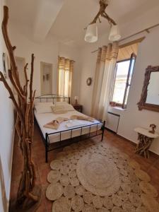 - une chambre avec un lit et un arbre dans l'établissement Traditional House Meloi, à Patmos