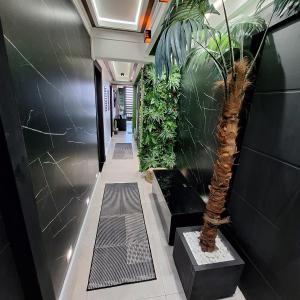 a hallway with a palm tree in a building at Oceanview Santos Gonzaga in Santos