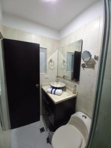 a bathroom with a toilet and a sink and a mirror at Hotel Panama in Neiva