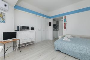 a bedroom with a bed and a desk and a tv at Apartamento Sol da Falésia in Sesimbra