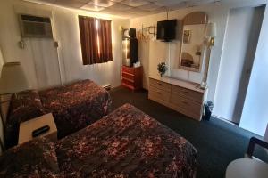 una camera d'albergo con due letti e una televisione di DuBois Manor Motel by OYO a Du Bois