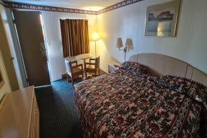 ドゥ・ボイスにあるDuBois Manor Motel by OYOのベッドとテーブルが備わるホテルルームです。