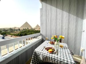 a table with a plate of food on a balcony at Colorful Pyramid Home in Cairo