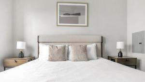 - une chambre avec un lit blanc et 2 tables de chevet dans l'établissement Landing Modern Apartment with Amazing Amenities (ID1802X52), à Austin