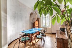 comedor con mesa azul y sillas en AD & Dezeen published apartment, en Roma