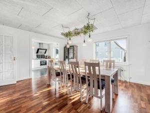 een keuken en eetkamer met een tafel en stoelen bij Holiday Home Ullakarin - 200m from the sea in Western Jutland by Interhome in Thyborøn