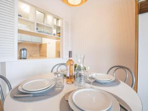 ein Esszimmer mit einem Tisch mit Tellern und Gläsern in der Unterkunft Apartment Aquitania-5 by Interhome in Arcachon