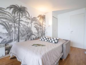 Schlafzimmer mit einem Bett mit Palmen an der Wand in der Unterkunft Apartment Aquitania-5 by Interhome in Arcachon
