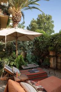 un patio con sombrilla, sillas y una palmera en AD & Dezeen published apartment, en Roma