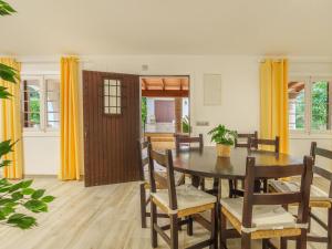 ポリェンサにあるHoliday Home Ullastro Pollença by Interhomeのダイニングルーム(木製テーブル、黄色のカーテン付)