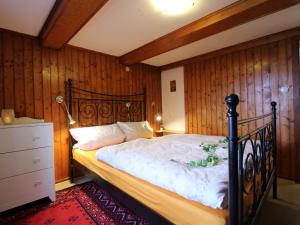 - une chambre avec un lit et un mur en bois dans l'établissement Apartment Blechnerhof-1 by Interhome, à Hinterfalkau