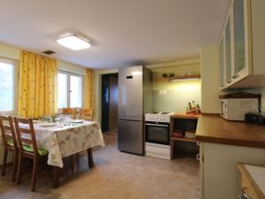 cocina con mesa y cocina con nevera en Apartment Blechnerhof-1 by Interhome en Hinterfalkau