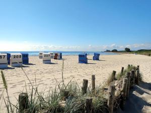 a beach with blue beach bins in the sand at Apartment Ostsee-Residenz - DMP173 by Interhome in Damp