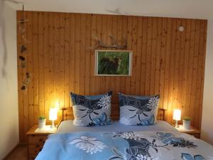 1 dormitorio con 1 cama con almohadas azules y blancas en Apartment Haus Ganter by Interhome, en Hinterzarten