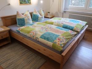 a bed with a quilt and pillows on it at Apartment Haus Ganter by Interhome in Hinterzarten