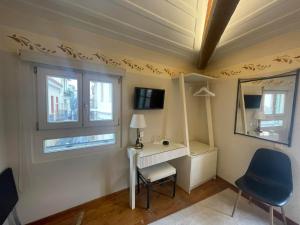a room with a desk and two windows at Pension Isabo in Nafplio