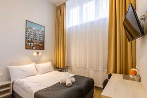 a hotel room with a bed with a towel on it at Zefiro Na Gnilnej in Gdańsk