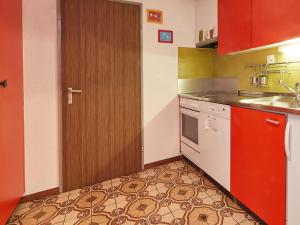 uma cozinha com uma porta vermelha e uma máquina de lavar louça branca em Apartment Wildhorn 322 by Interhome em Les Collons