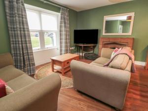 Sala de estar con 2 sofás y TV en Salmon Cottage, en Berwick-Upon-Tweed