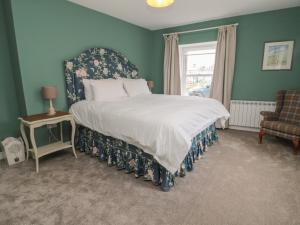 a bedroom with a bed and a chair and a window at Salmon Cottage in Berwick-Upon-Tweed
