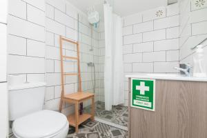 a bathroom with a toilet and a sign on a counter at Apartamento Sol da Falésia in Sesimbra +13 photos