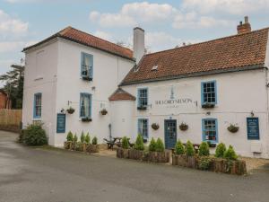 a white building with blue shutters on a street at Cedar Lodge in Newark-on-Trent