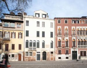 une personne faisant du vélo devant certains bâtiments dans l'établissement The Lovers' Loft, à Venise